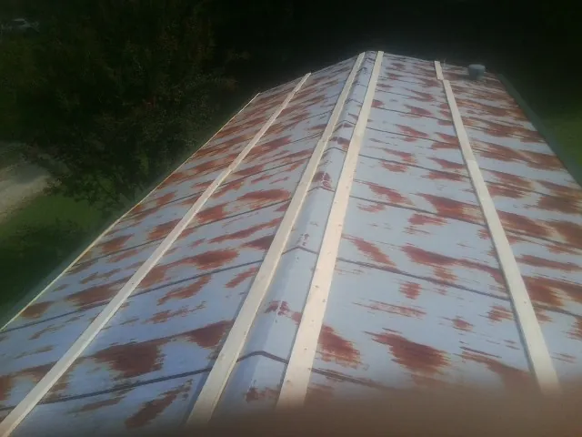 Rusted metal roof panels with new wood purlins before replacement — Storm Damage Roof Repair in Hereford by Roofing Brothers