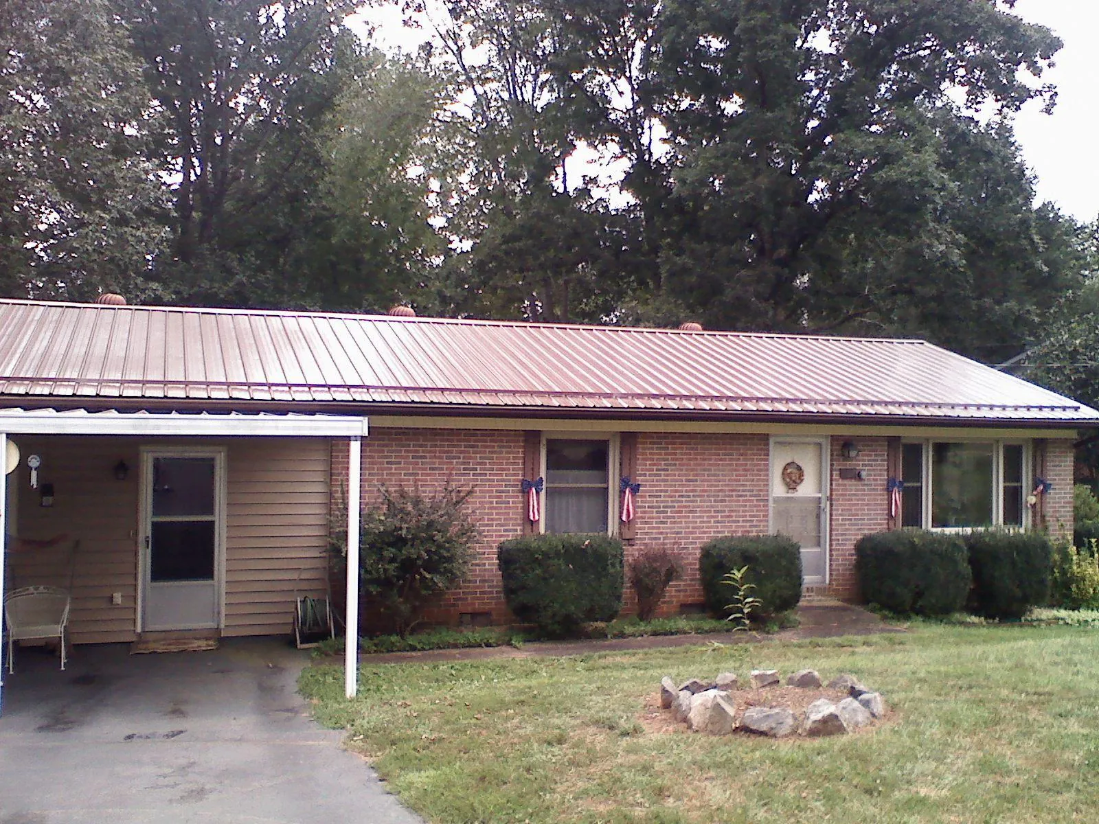 Bronze metal roof and carport on a brick ranch home — Roof Repair work by our crew in Hereford